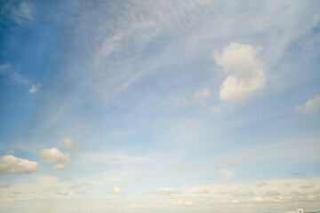 White cumulus clouds in the blue sky. Bright beautiful sky, copy space background