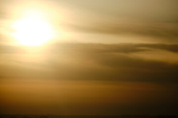 Evening dramatic sky with clouds during sunset. The sun sets behind dark clouds