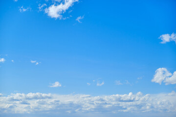 Naklejka na ściany i meble Blue sky with white cumulus clouds. Bright sunny day with cloudy sky