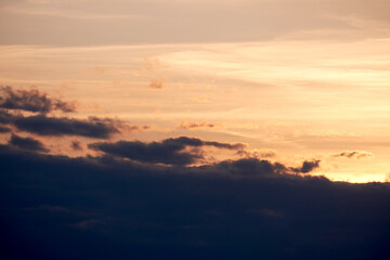 Fototapeta na wymiar Dark clouds in the evening sunset sky with the setting sun. Dramatic sky during orange sunset