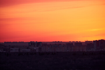 Dramatic sky with red clouds over the evening dark city