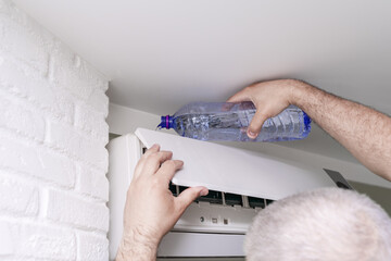 worker to cleaning coil cooler of air conditioner by water for clean a dust on the wall in customer...