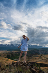 Fototapeta premium Woman in blue dress in summer Altai mountains in Kurai steppe