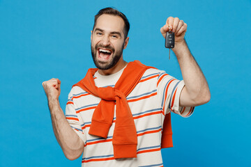 Young excited caucasian man 20s in orange striped t-shirt looking camera hold car keys fob keyless...