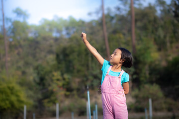 a little girl raise hand in cabbage plant. Cute little girl on cabbage field.