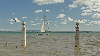 Sailship on river Tagus with pillars of Cais da colunas quay in front, Lisbon, Portugal