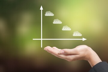Business man's hand raising amount of CO2 emissions graph concept