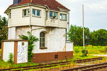 Green and peaceful train station building and railroad tracks Germany.