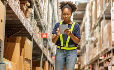 female African American employee \wearing a uniform  work to inspect goods in the warehouse.