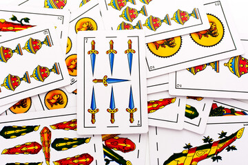 Spanish card game, spanish deck Tarot cards, the swords card in the foreground.