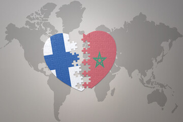 puzzle heart with the national flag of morocco and finland on a world map background. Concept.
