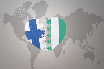 puzzle heart with the national flag of nigeria and finland on a world map background. Concept.