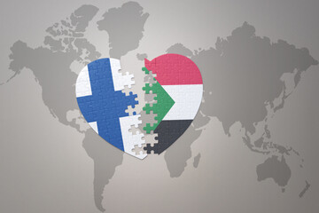puzzle heart with the national flag of sudan and finland on a world map background. Concept.
