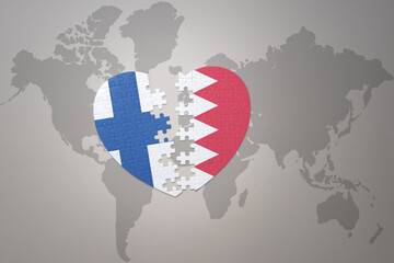 puzzle heart with the national flag of bahrain and finland on a world map background. Concept.