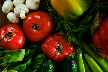 Vegetables on a wooden table. Seasonal vegetables. Tomatoes, peppers, cucumbers, mushrooms on the table.