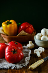 Vegetables on a wooden table. Seasonal vegetables. Tomatoes, peppers, cucumbers, mushrooms on the table.