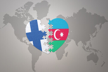 puzzle heart with the national flag of azerbaijan and finland on a world map background. Concept.