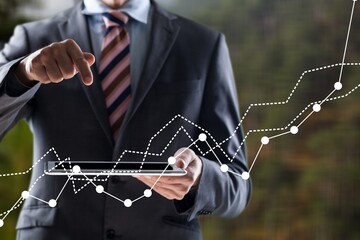 Business man's hand raising amount of CO2 emissions graph concept