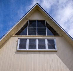 Pastel Yellow A Frame House with Picture Windows.