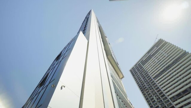 View of skyscrapers at low angle. Look into future. View from below of modern skyscrapers in business district. Business concept of success industry or real estate investment. Camera rotation.