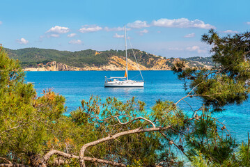 Fototapeta premium White small yacht drifting in the tropical sea