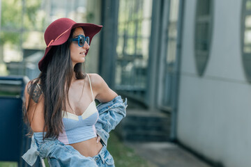 urban style hipster girl in sunglasses and hat on the street