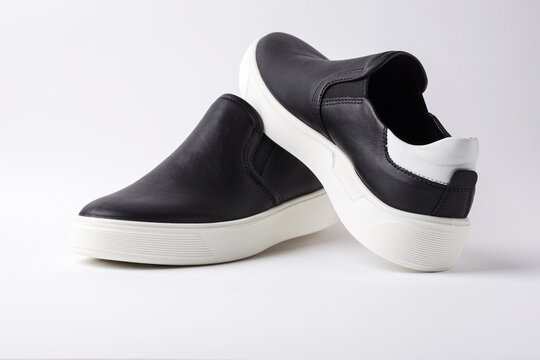Black leather slip-ons shoes on white background.