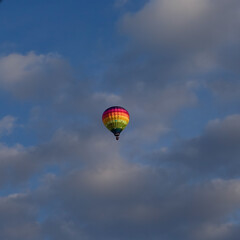 Montgolfière multicolore dans un ciel nuageux