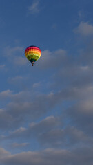 Montgolfière multicolore dans un ciel nuageux
