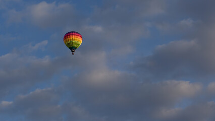 Montgolfière multicolore dans un ciel nuageux
