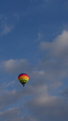 Montgolfière multicolore dans un ciel nuageux