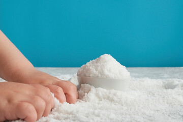 Close-up of the baby's hands, which deals with bulk material, hand motility, sand or sugar, salt....