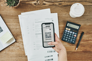 Woman paying for energy scanning QR code from bill. Making payment using QR scanner and fast secure...