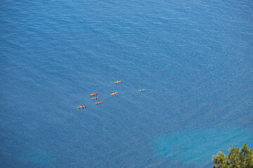 Scene from a summer vacation. Several kayaks with rowers on the Adriatic Sea taken from above....