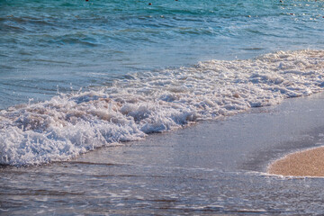 Soft wave of the sea on the sandy beach.
