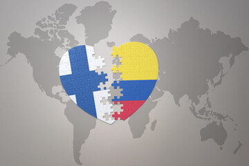 puzzle heart with the national flag of colombia and finland on a world map background. Concept.