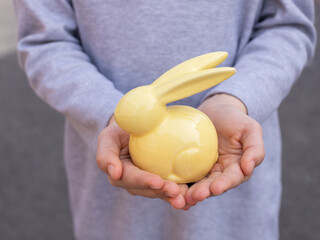 girl holding a ceramic rabbit in her palms