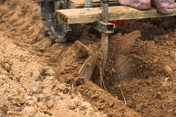 Fototapeta na wymiar Plowing and sowing the soil with a farm tractor in an agricultural field in spring