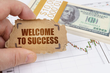 Against the background of dollars and a chart of quotations, a man holds a sign with the...