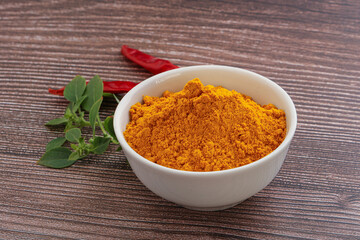 Yellow vibrant curcuma powder in the bowl