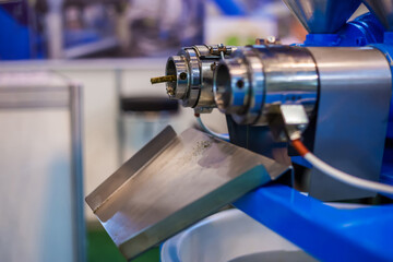 Close up view - pet food extruder machine: mixed feed production line at factory, plant, exhibition, trade show. Farming, extrusion technology equipment, agriculture industry, animal husbandry concept