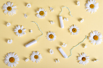 women's tampons and bloom chamomile pattern on a beige pastel background. idea women's health flat ley
