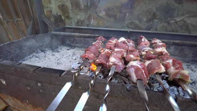 Pickled kebab is cooked on grill on coals. Barbecue is popular in Eastern Europe. Mouth-watering pieces of marinated meat strung on skewers cooked with charcoal grills in fragrant hot smoke. Close-up