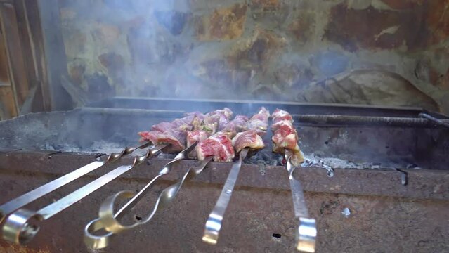 Pickled kebab is cooked on grill on coals. Barbecue is popular in Eastern Europe. Mouth-watering pieces of marinated meat strung on skewers cooked with charcoal grills in fragrant hot smoke. Close-up