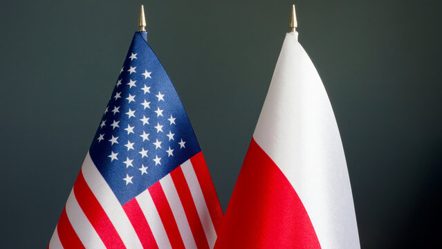 Flags Of The USA And Poland On A Dark Surface.