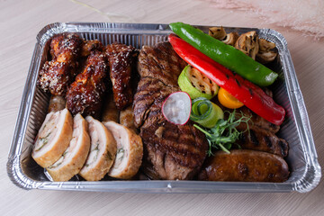 delivery of fresh grilled meat dishes in metal packaging