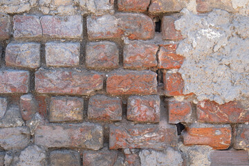 old and weathered brick wall. unplastered concrete surface.