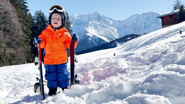 Boy at ski school three years old child in snow over mountains