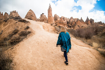 Young happy woman traveler enjoying a vacation in desert Cappadocia Turkey. Tourist girl active...