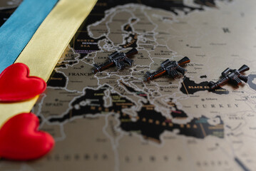 Machine guns on the background of a map of Europe and hearts with the Ukrainian ensign.